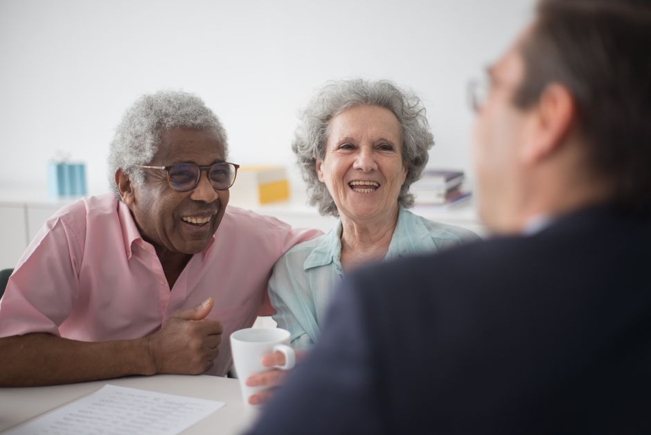 A family weighing whether long-term care insurance is worth it while sitting with an elderly relative at home